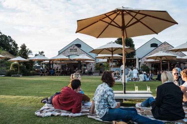 husk distillers sitting on lawn drinking cocktails in NSW